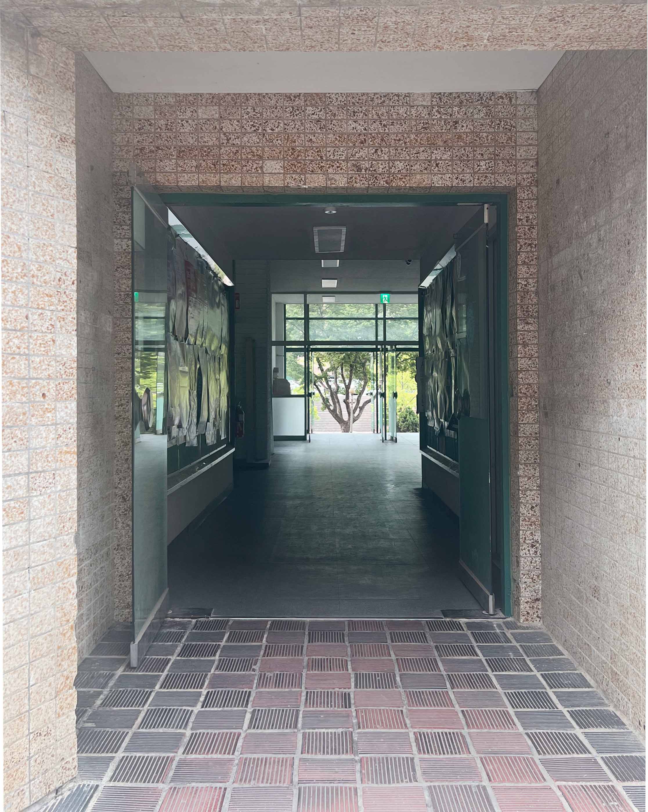 중간에는 초록색 유리문이 열려있다. 양쪽 끝에 있는 벽과 천장은 상아색 또는 연한 갈색이다. 바닥은 붉은 색의 벽돌 타일들로 이루어져 있다.