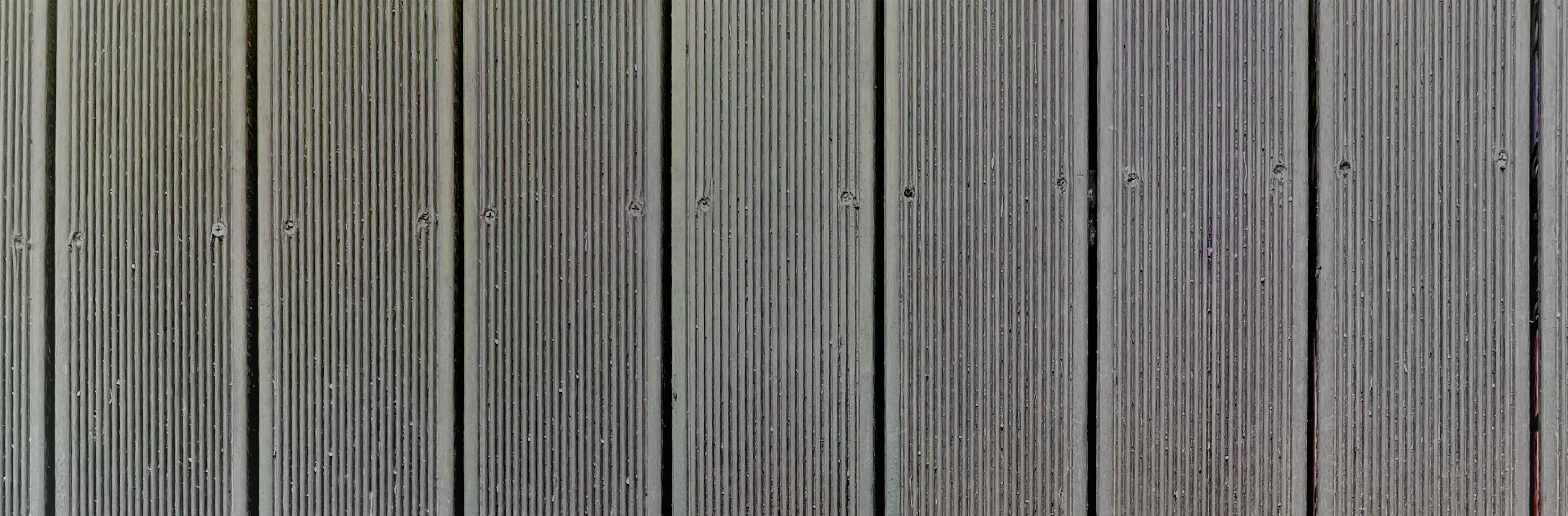 전체적으로 진한 갈색 또는 흑갈색에, 미끄럼 방지 처리가 되어 있는 나무 바닥 사진이다.