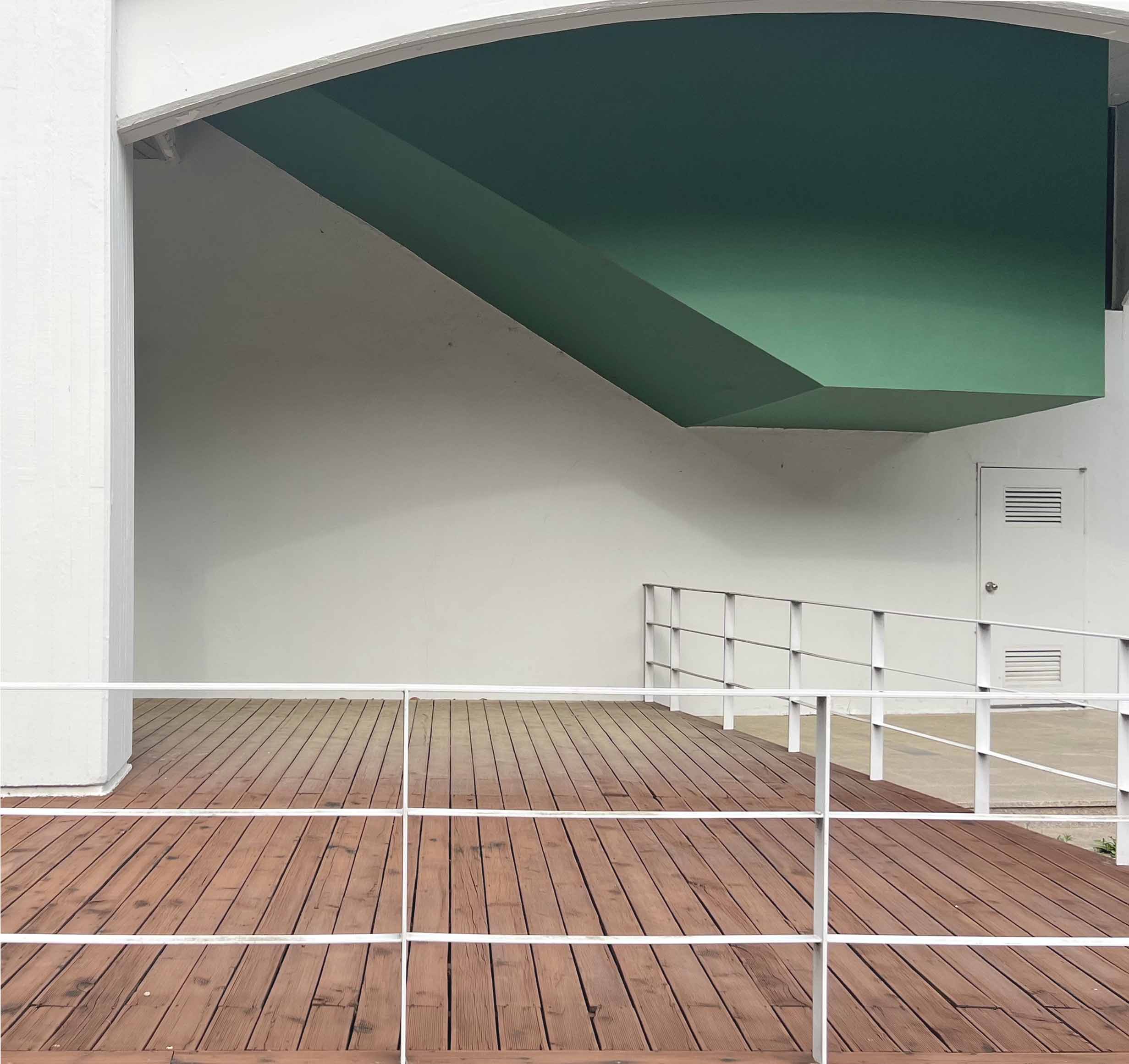 왼쪽 끝에 흰색 네모 모양 기둥이 있고 그 위로 초록색 사다리꼴 모양의 구조물이 있따. 바닥은 붉은 나무판으로 이루어져 있고 흰색 울타리가 감싸고 있다.