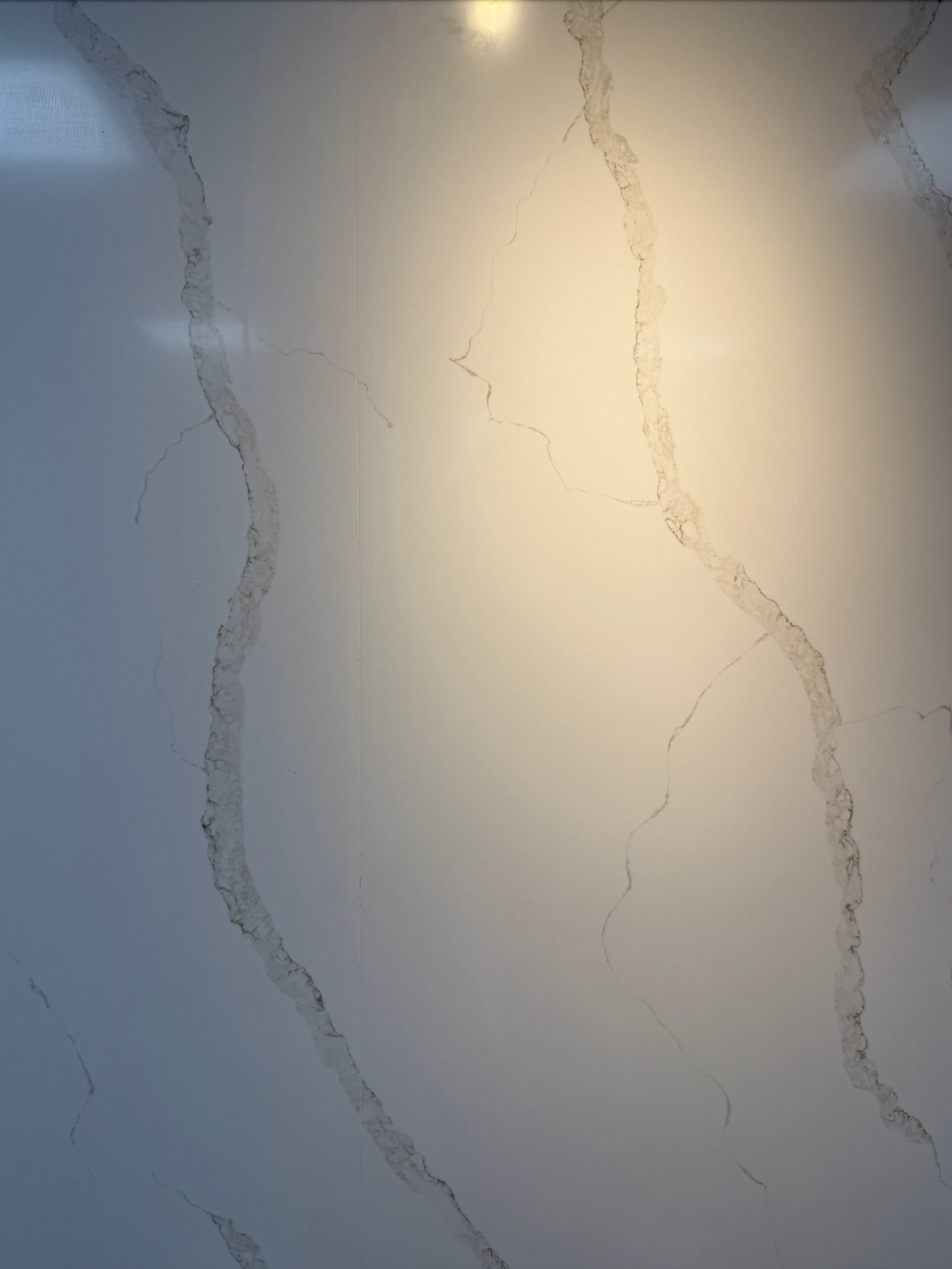 매끈한 벽의 갈라진 틈 사이에 콘크리트를 넣고 연마 한 벽이다.