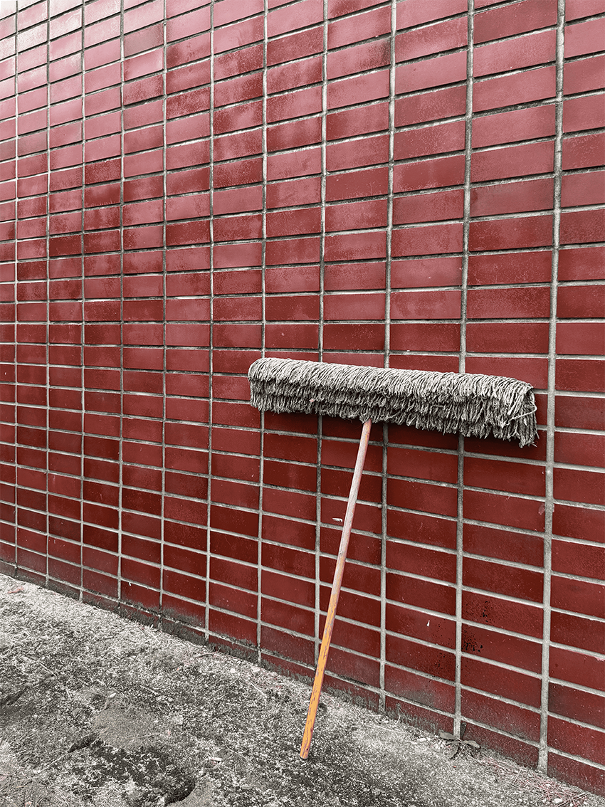 붉은 벽돌로 이루어진 벽이며 앞에 밀대가 세워져 있다.벽의 오른쪽에 서서 왼쪽을 향해 찍은 것이다.