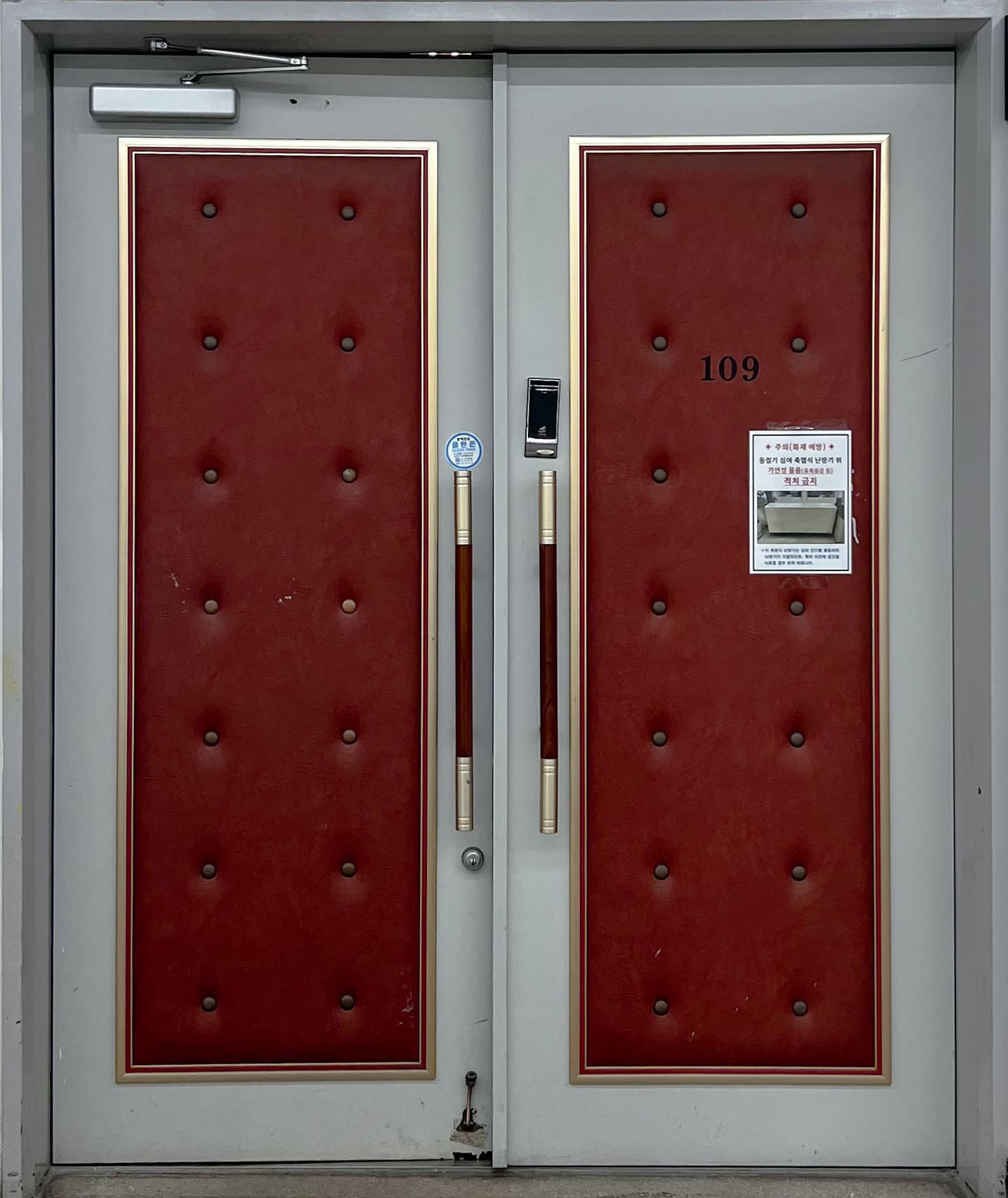 회색 틀에 노란색 테두리로 감싸진 빨간색 쿠션이 붙어있는 복합재료가 사용된 방음문이다.