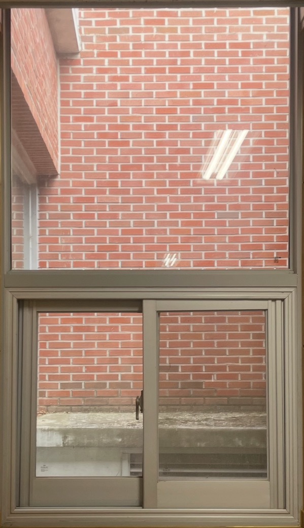 철제 프레임과 옆으로 밀어서 여는 슬라이드 창문으로 세로로 하단에 긴 형태의 2개의 창이 보이는 사진