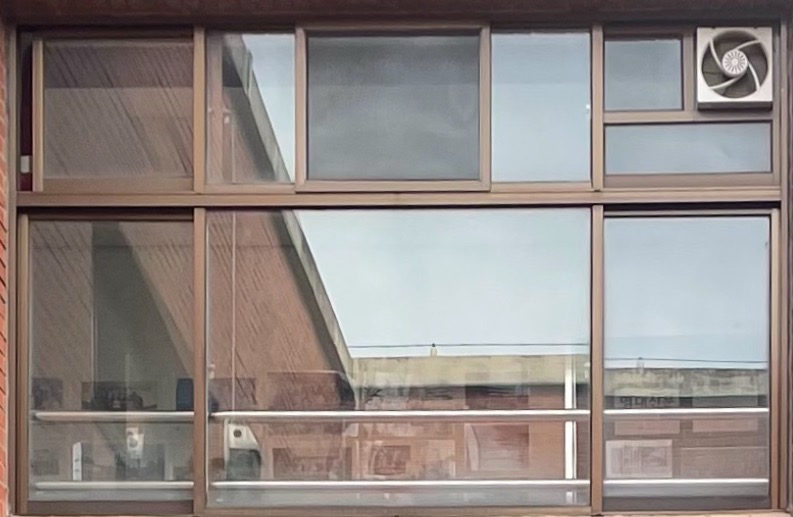 옆으로 밀어서 여는 방식의 중앙고정 창문과 아래에 작은 중앙고정 창문이 함께 있는 사진 갈색의 철제 프레임으로 되어있다