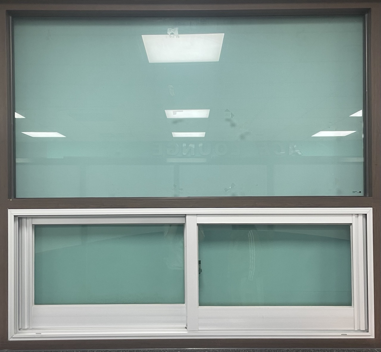 갈색 철제 프레임과 하단에 옆으로 밀어서 여는 슬라이드 유형의 흰 플라스틱 프레임 창문의 사진