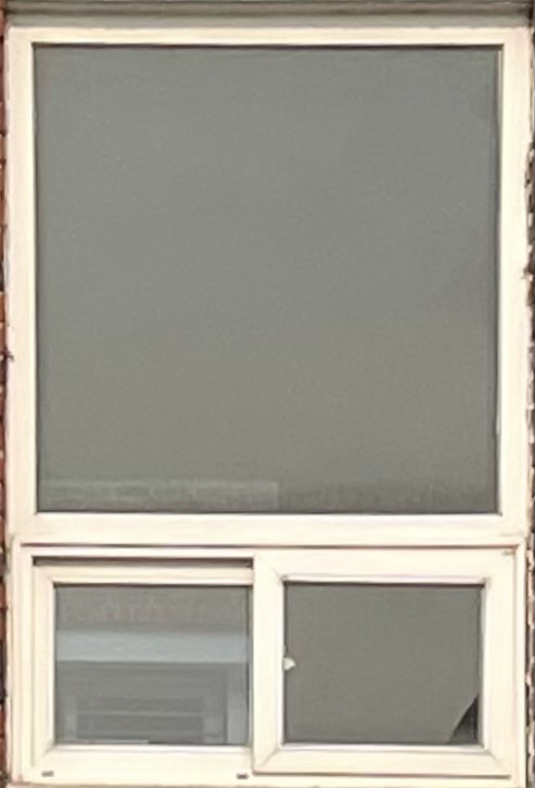 큰 정사각형과 그 아래 작은 창의 흰색의 프레임으로 구성된 옆으로 밀어서 여는 슬라이드 유형의 창문 사진