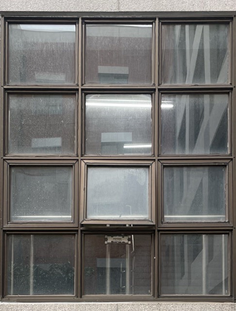 검은색 철제 프레임에 가로 3, 세로 4개의 창이 같은 크기 모양인 안쪽으로 기울여 열려있는 방식의 틸트 창문의 사진