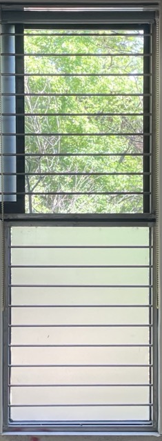 세로로 긴 창이 아래로 2개가 달려있고 옆으로 밀어서 여는 슬라이드 창문의 사진 창문의 앞에 가로로 얇은 창살이 달려있는 사진