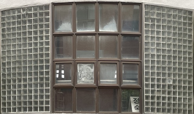 가로 세로로 4개의 창이 달려있고 그 양 옆으로 정 사각형의 작은 투명 유리 블록이 여러개 붙여져 있는 모양