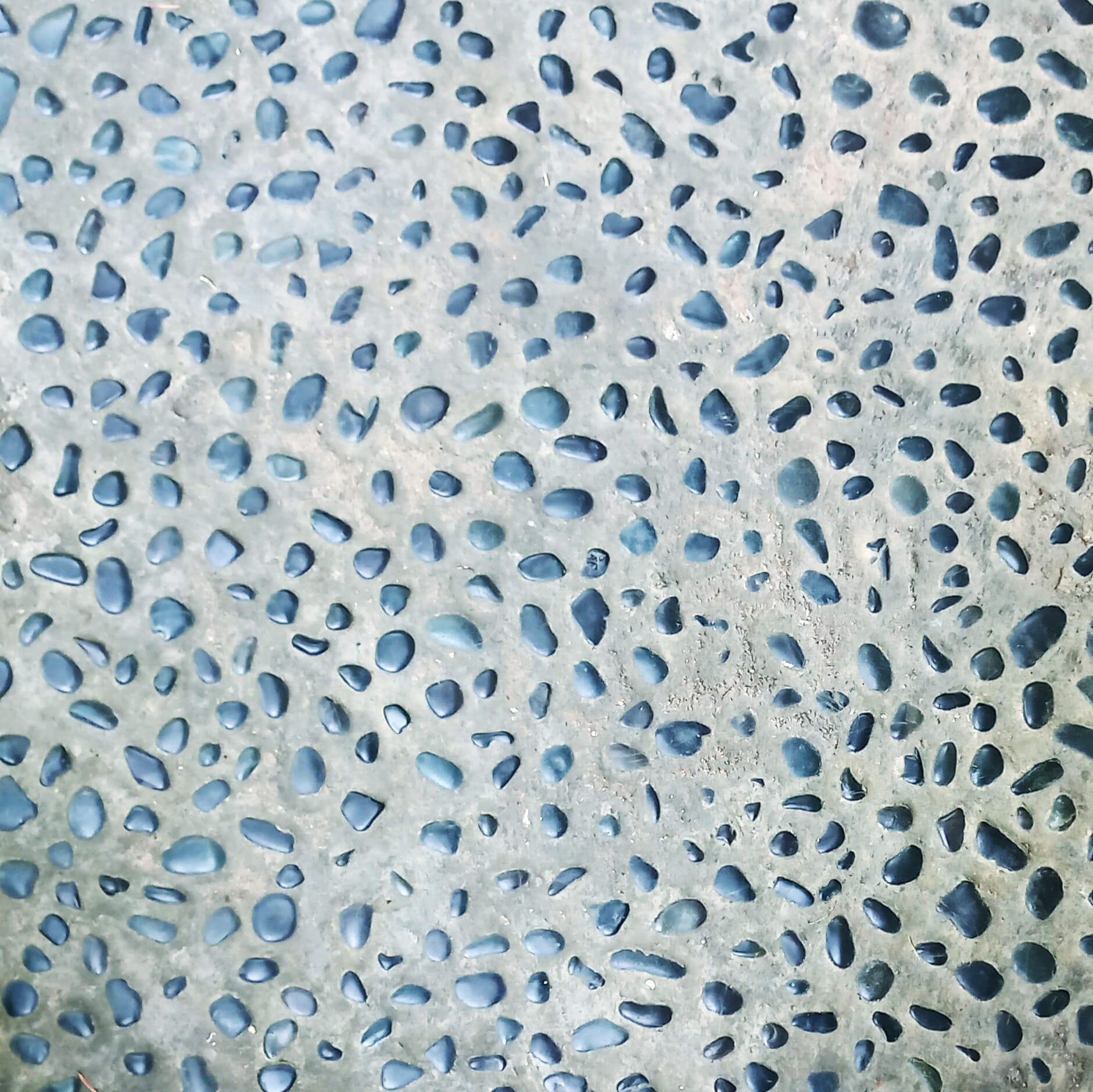밝은 회색 바탕. 청색이 섞인 회색 조약돌들이 촘촘하게 박혀있다.