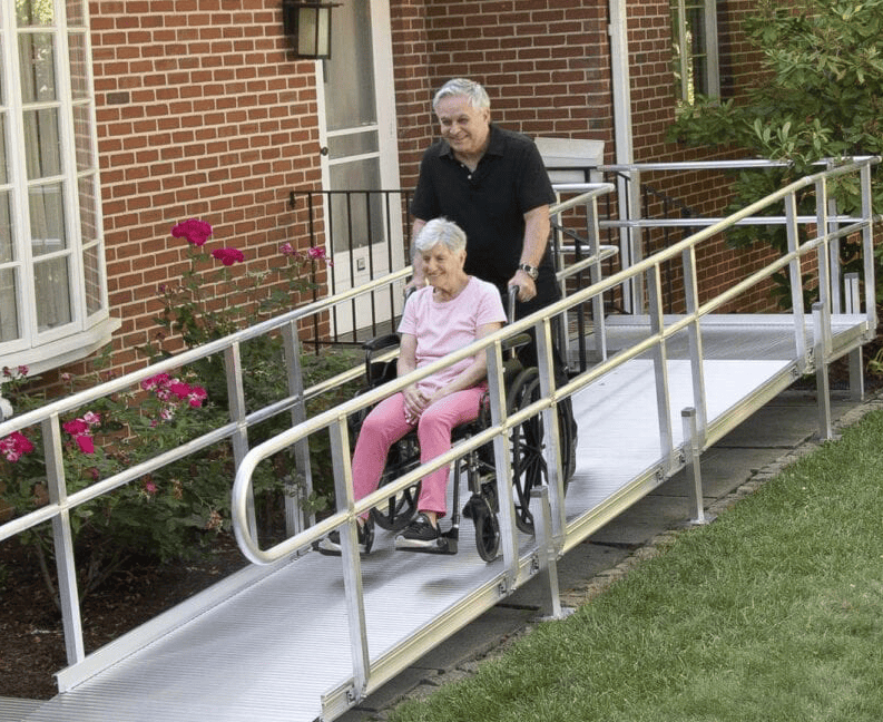 휠체어에 탄 할아버지를 램프를 이용하여 끌고 가는 할머니