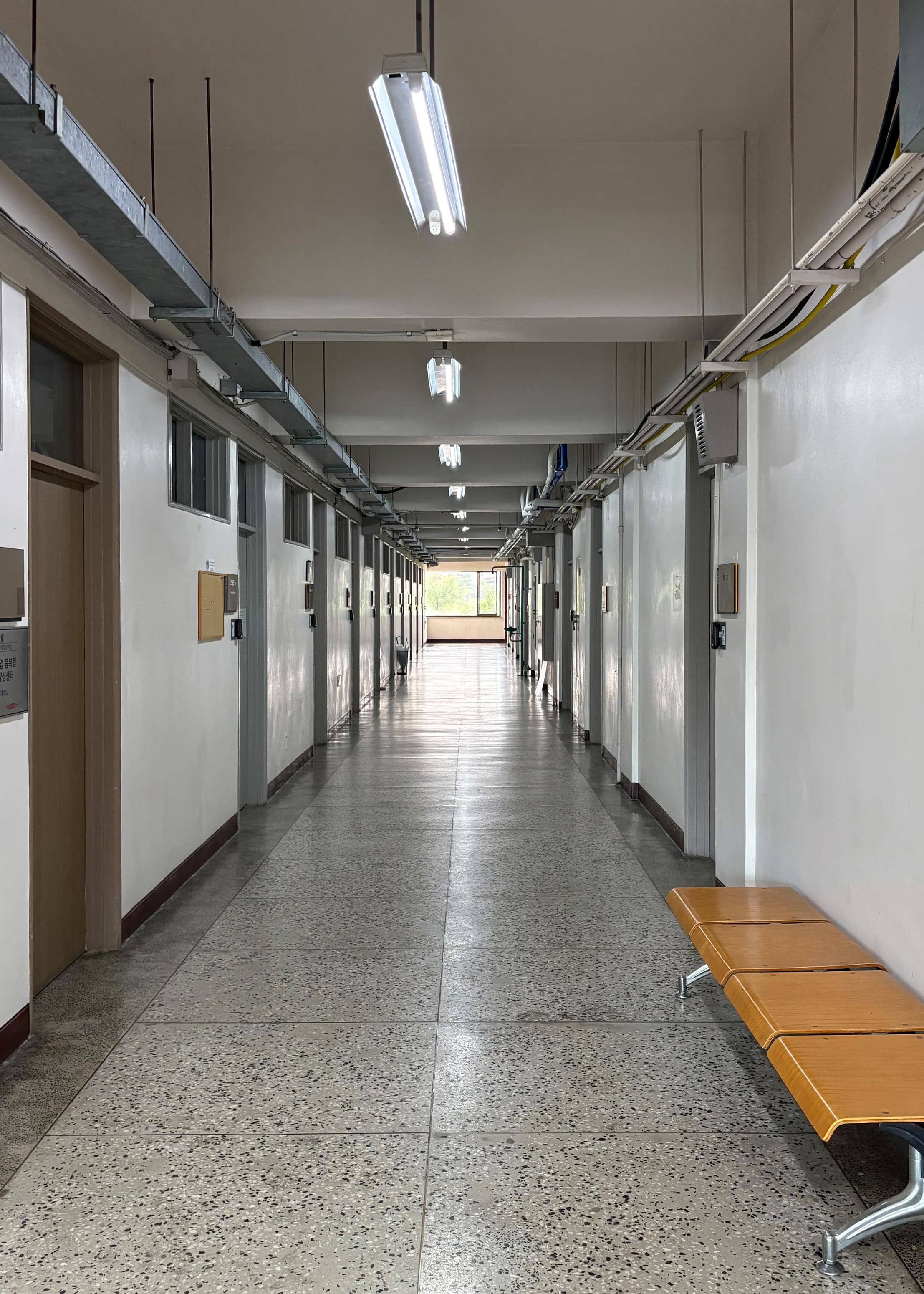 영남대학교 화공관 2층 중복도. 오른쪽에는 갈색 의자가 있다. 그리고 왼쪽과 오른쪽에는 여러 개의 교수실이 나열되어 있다. 복도 끝에는 큰 창문이 있다. 