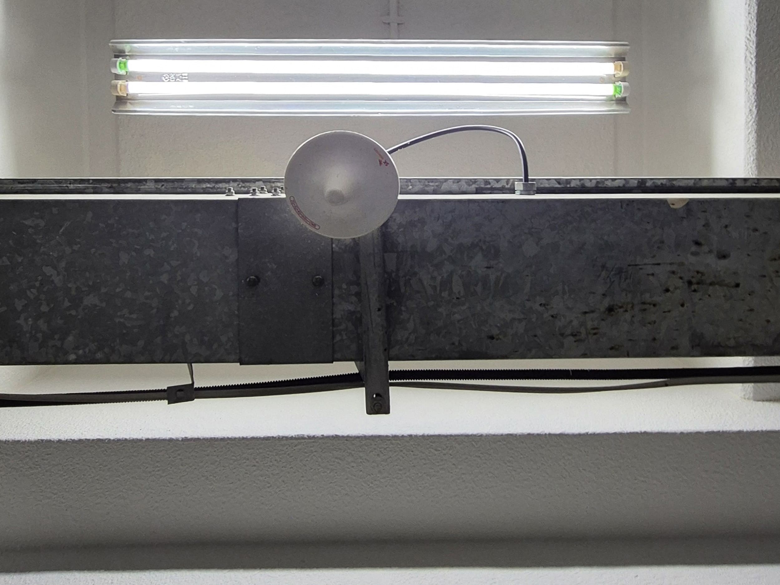 흰색의 천장과 천장 가운데에 세로로 나란히 배치된 긴 형광등이 가로로 배치되어 있다.