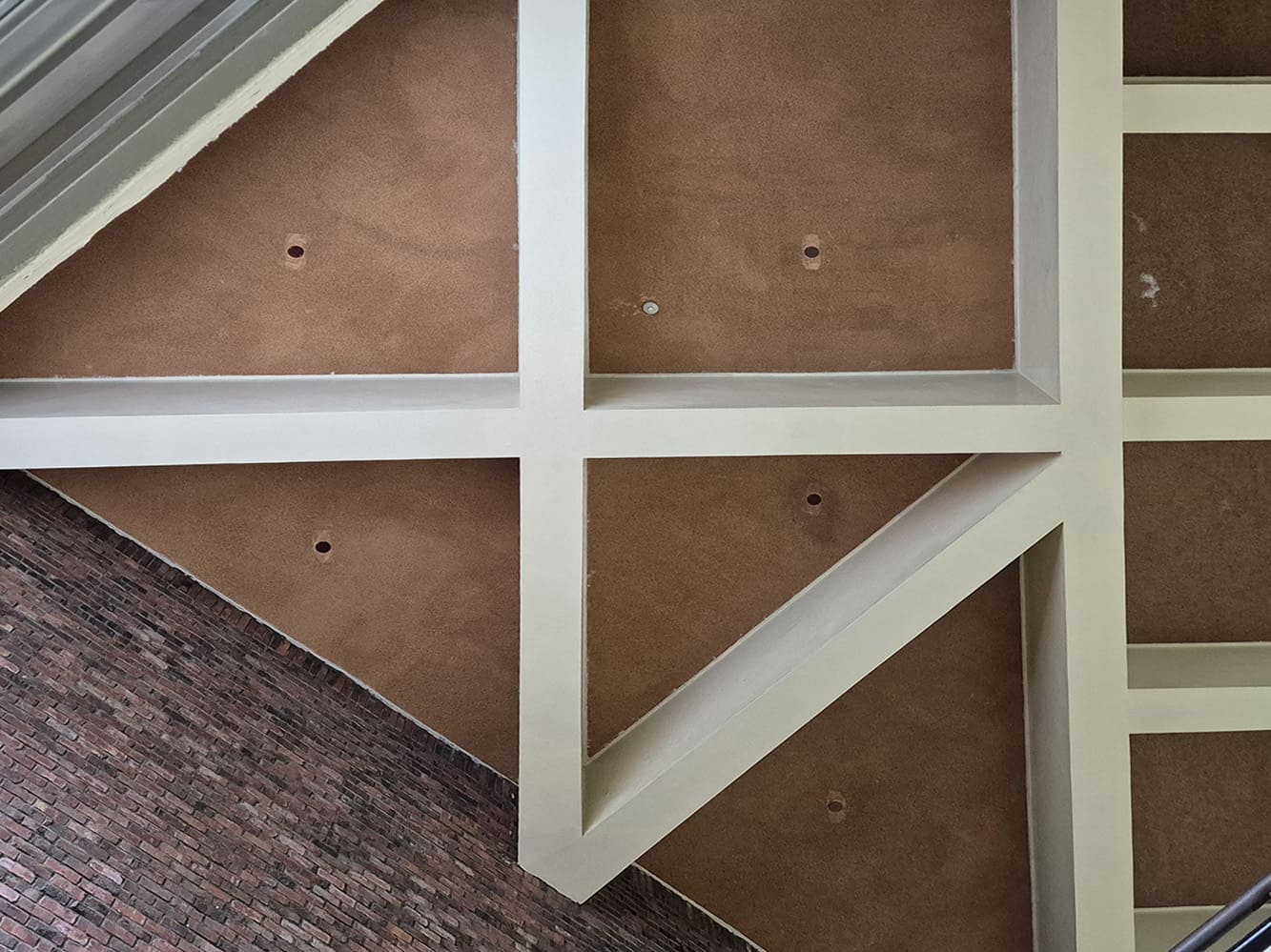 아이보리 색 삼각형 격자,사각형 격자 등의 프레임이 천장에 설치되어 있다. 이와 대비되는 연한 갈색 계열의 천장이다. 천장을 측면에서 찍은 사진