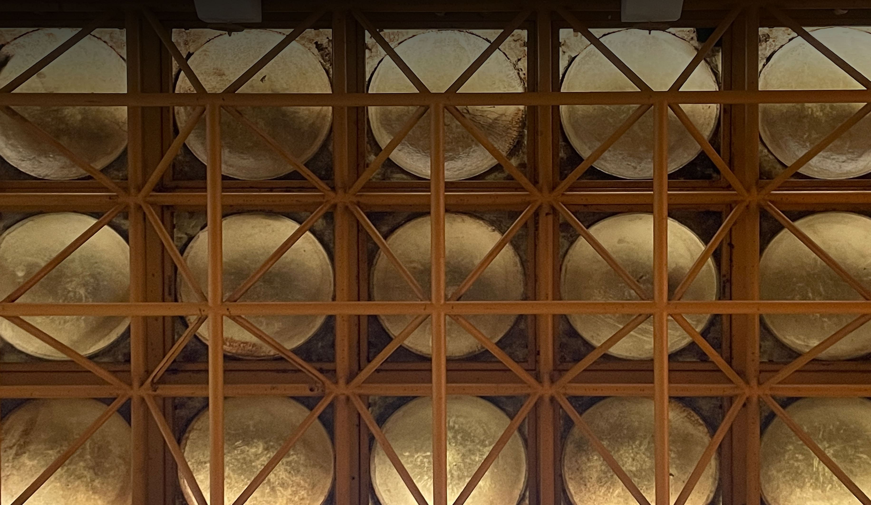 혼합형 페이지의 대표이미지인 이 천장은 영남대학교 디자인관 1층 건물에서 촬영하였다. 전체 구조는 네모난 격자 프레임으로 구성되어 있으며, 각 격자 안에는 속이 파인 둥근 반구형 음각 구조물이 들어 있다. 이 반구들은 콘크리트 재질로, 표면이 매끄럽지 않고 거칠며 얼룩이나 먼지가 쌓인 흔적이 있어 오래된 느낌을 준다. 뼈대는 주황빛 철제 구조물로, 수직과 수평뿐 아니라 대각선으로도 연결되어 격자가 더욱 복잡하고 견고하게 교차되어 있다.