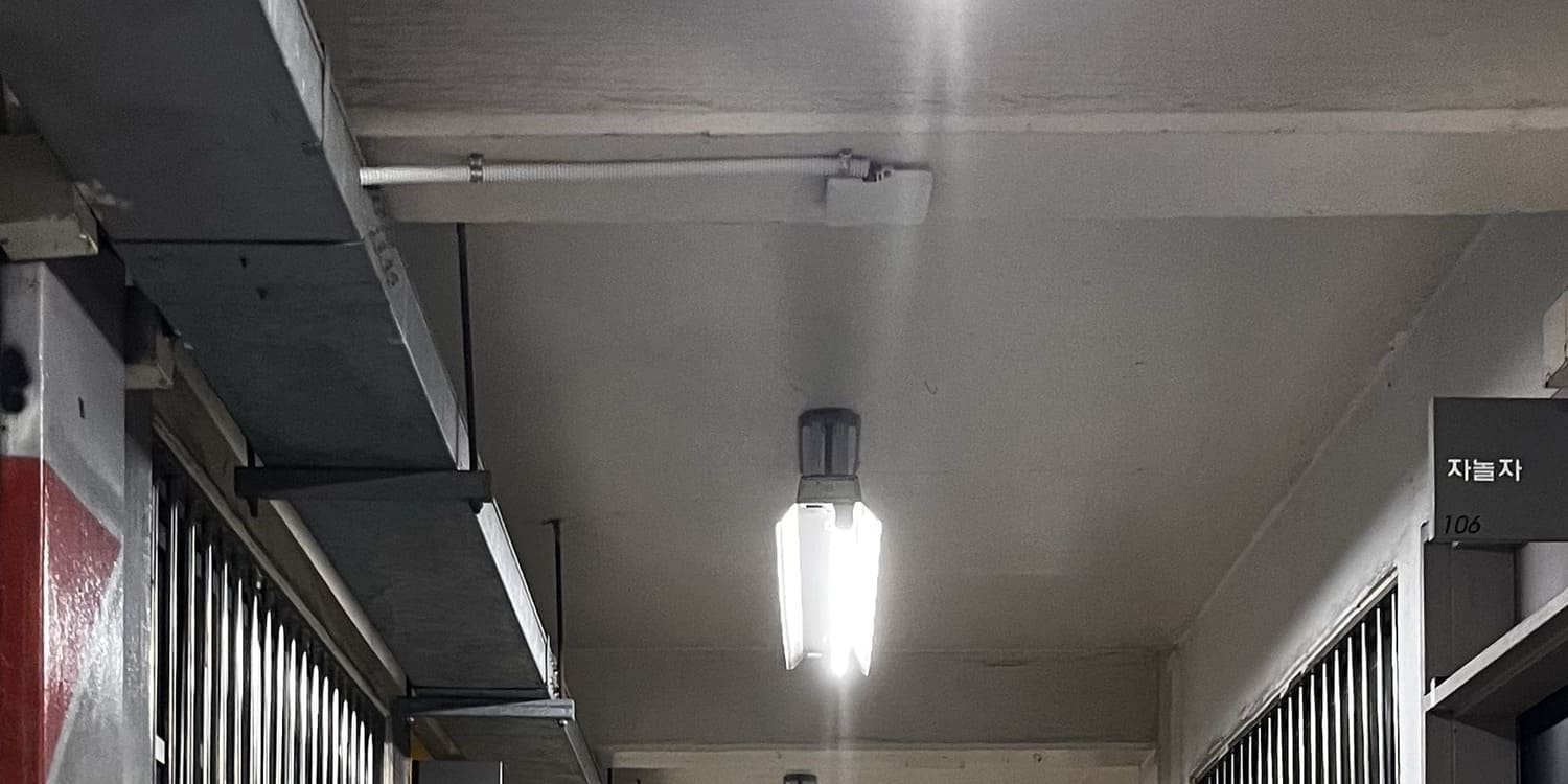 중간에 소실점이 있는 사진을 세로로 3분할 한 사진의 맨 위. 콘크리트에 시멘트 천장과 벽,노출형 형광등. 2구 형광등의 왼쪽이 빠져있다. 천장에는 짧은 보가 2개 있다.왼쪽 벽에는 회색 페인트 위에 빨간색 그래비티의 부분이 잘려있다.왼쪽 천장에는 철제 덕트가 달려있다. 2번 사진의 맨 위