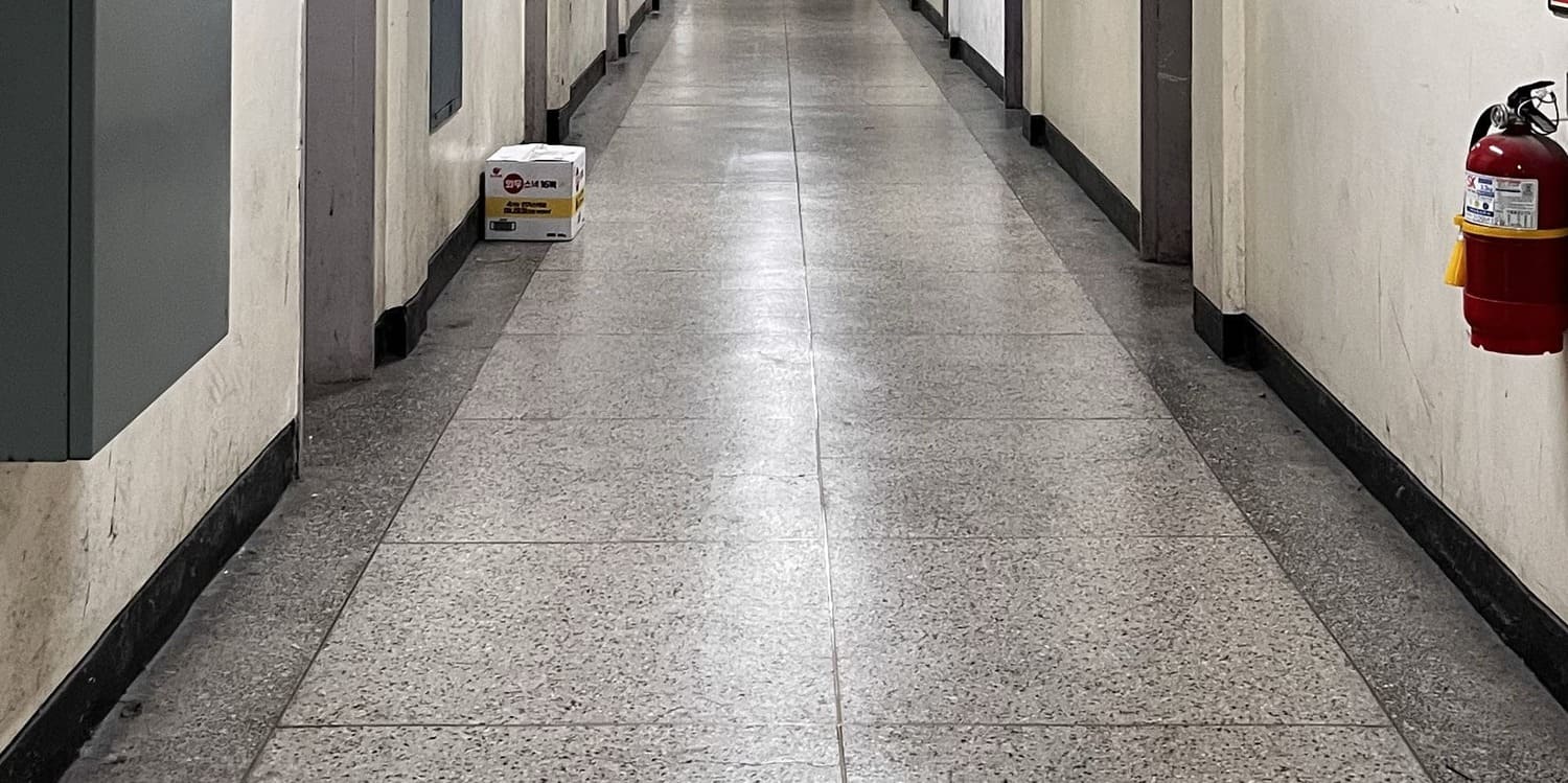 중간에 소실점이 있는 사진을 세로로 3분할 한 사진의 아래. 오른쪽 벽에는 소화기가 매달려있고 왼쪽 벽에는 철제함의 아랫부분이 잘려있다.1번 사진의 아래.