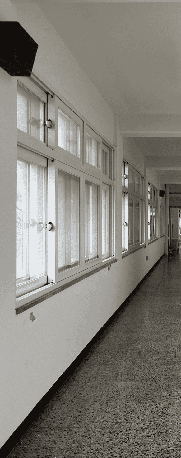 중앙에 소실점이 위치한 채 찍힌 사진의 중앙부터 왼편까지의 절반. 흰색 벽과 천장, 천장 중간중간 짧은 보가 내려와있다. 벽에는 흰색 알루미늄 창들이 4개씩 거의 빼곡하게 설치되어있다. 사진 속에는 총 2개의 스피커가 창문의 맨 위와 같은 높이에 설치되어있다. 