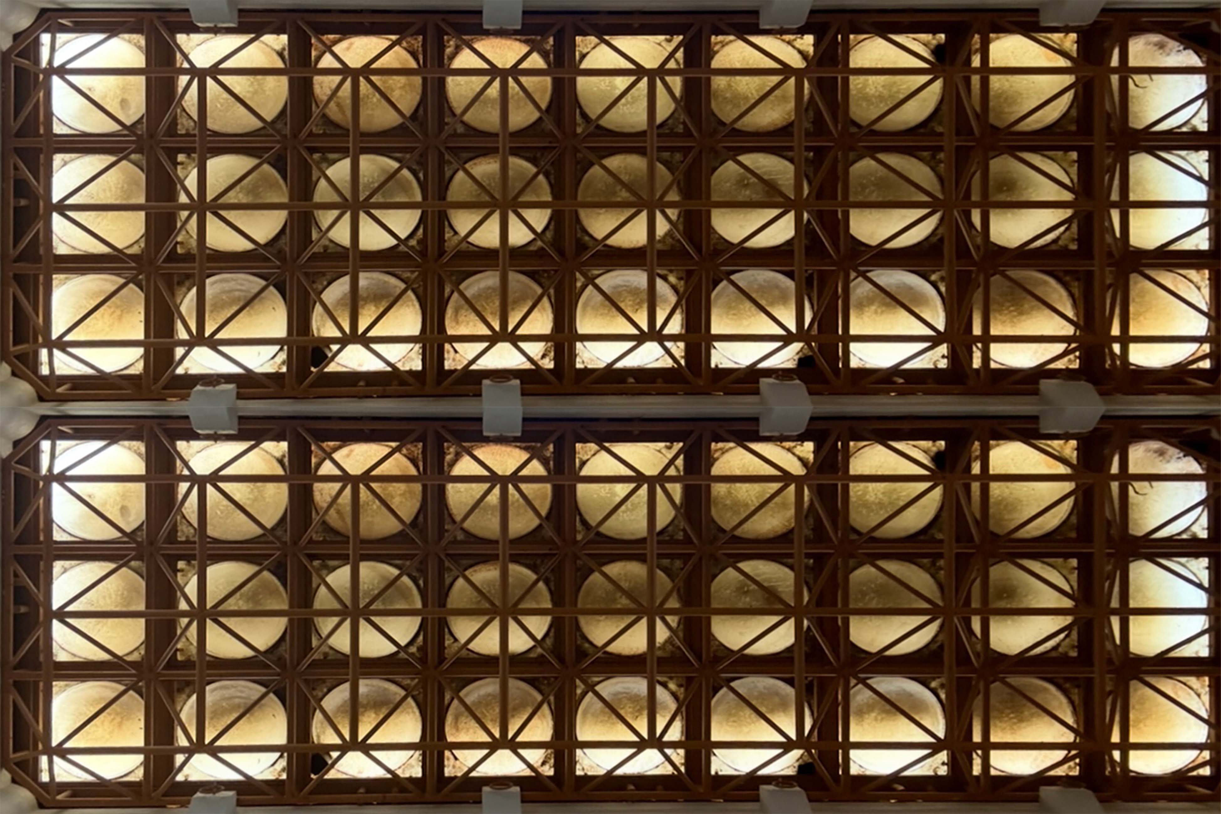 정사각형의 갈색 격자 구조 속에 볼록 나온 둥근 반투명체 판이 있다. 은은한 빛을 받아 노란색 빛이 서서히 퍼진다.