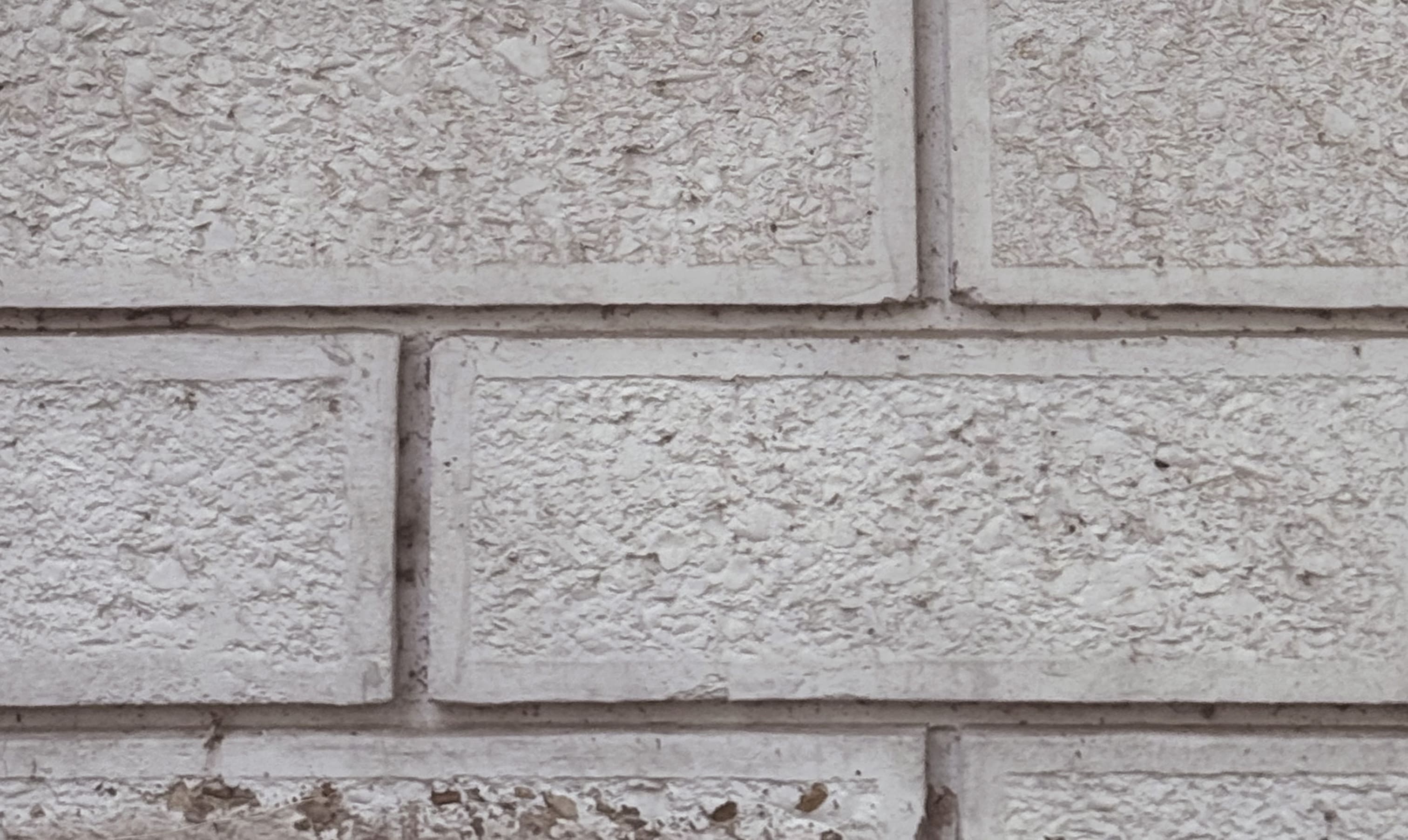 하얗고 울퉁불퉁한 돌들이 직사각형 모양으로 벽돌처럼 층층이 쌓여 있습니다.