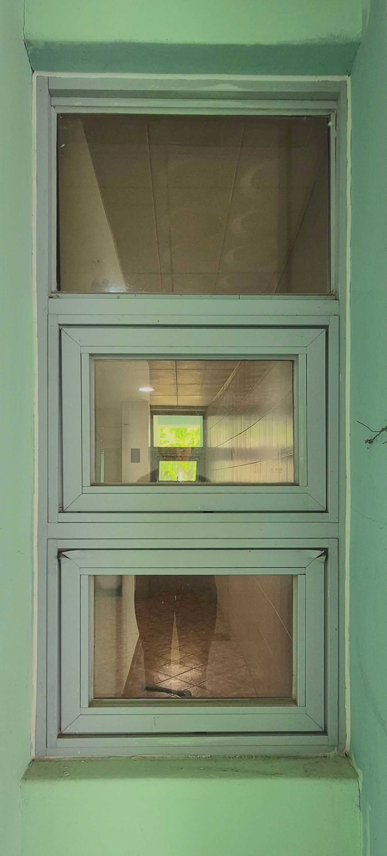 건축관 창문, 민트색 벽 위로 흰 창틀로 된 직사각형 형태의 창문이 있다. 한 줄씩 세로로 3개가 붙어있는 모양이다. 가장 위쪽의 창문은 아래 두 창문에 비해 창틀이 얇다.