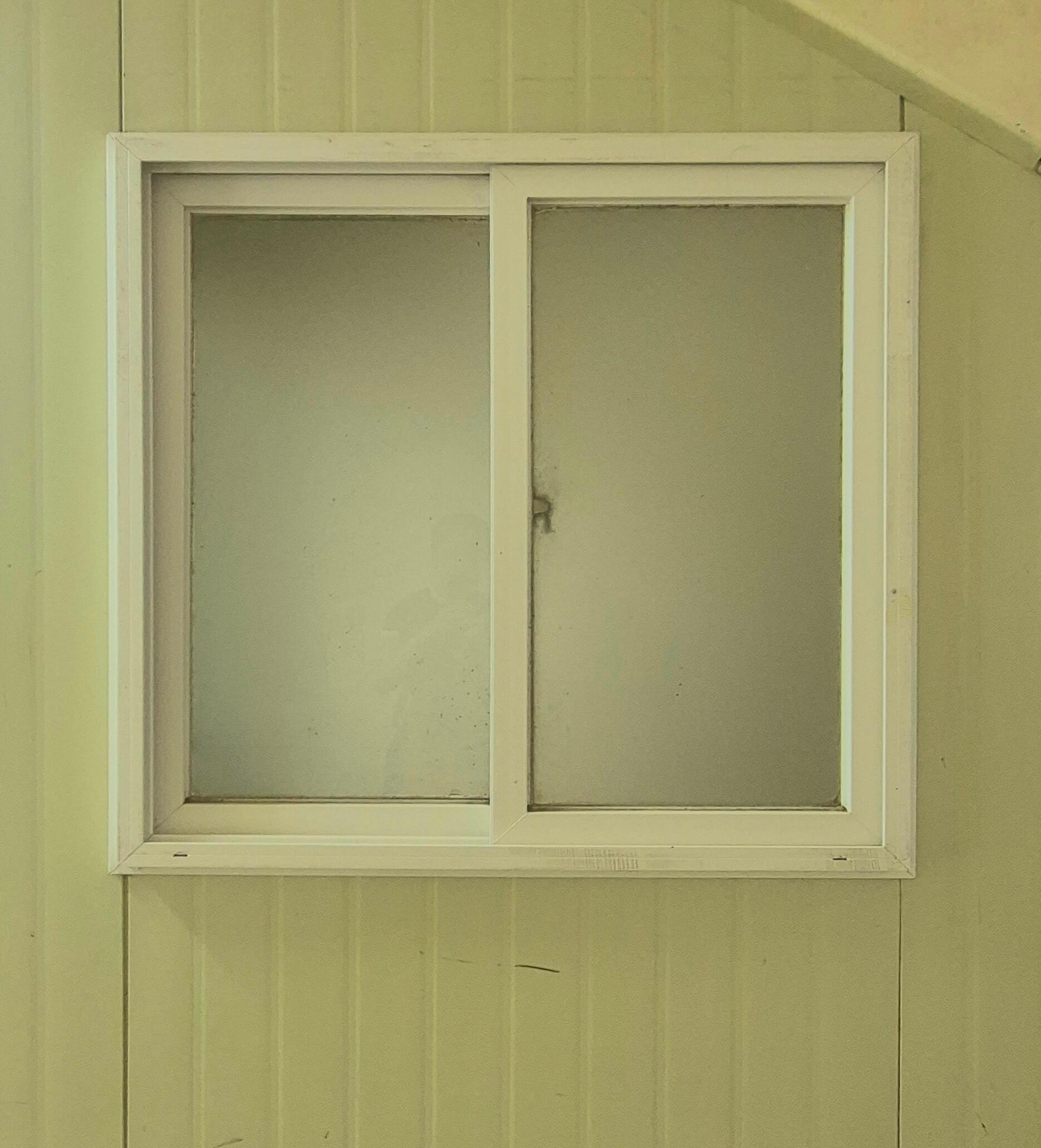 인문관 창문, 계단 옆쪽의 벽에 있는 창문이다. 연두색 벽 위로 휜 창틀로 된 직사각형 형태의 창문이다. 세로로 긴 직사각형 두 개가 나란히 붙에있는 형태이다.