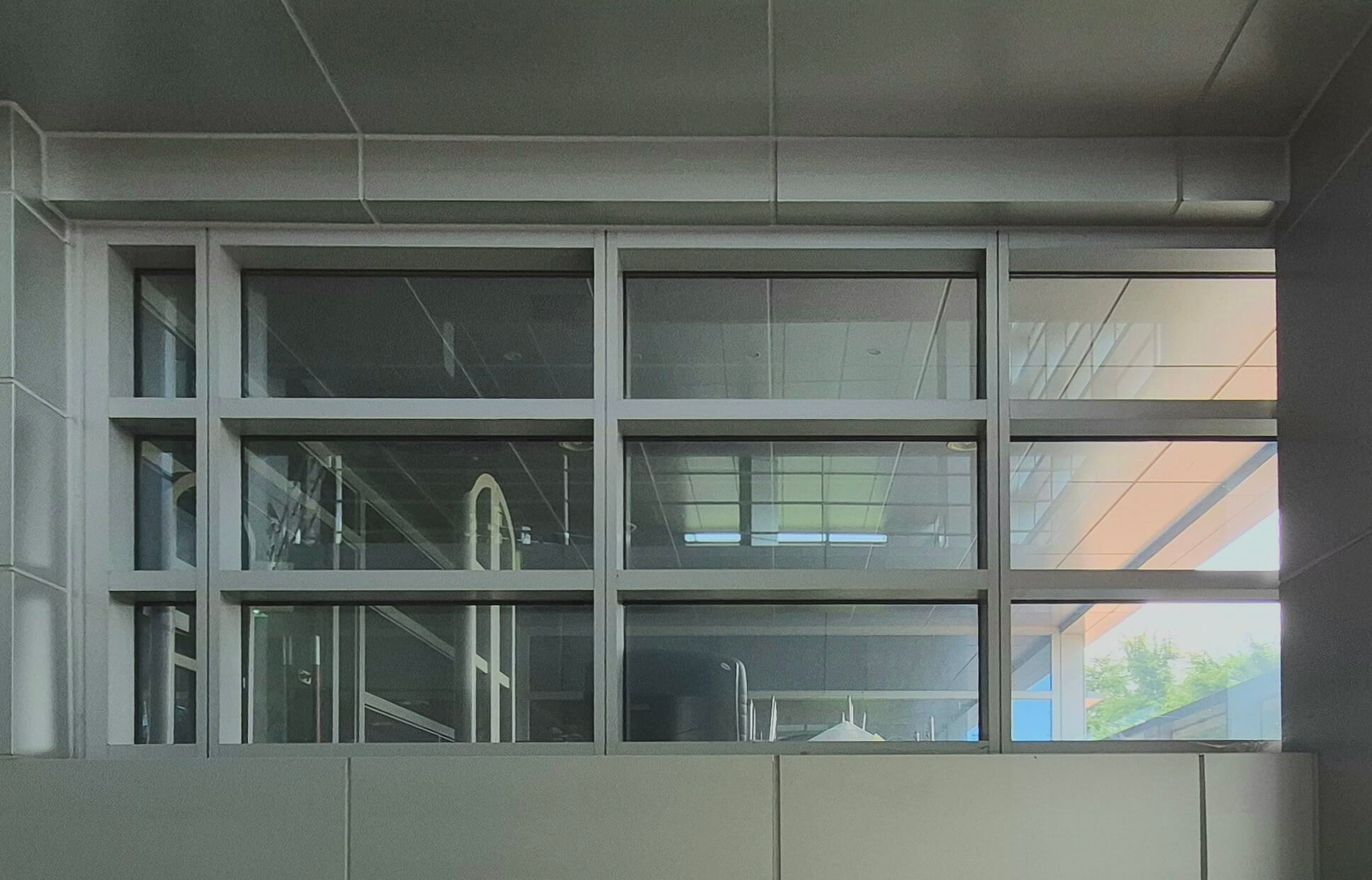 중앙도서관 창문, 회색 벽 위로 흰 창틀로 된 작시각형 형태의 창문이 있다. 가로로 긴 직사각형이 좌우로 3개싹, 위 아래로 3개씩 놓여있고, 맨 왼쪽에는 좌우 너비가 다른 창에 비해 좁은 창문이 한 줄 있다. 